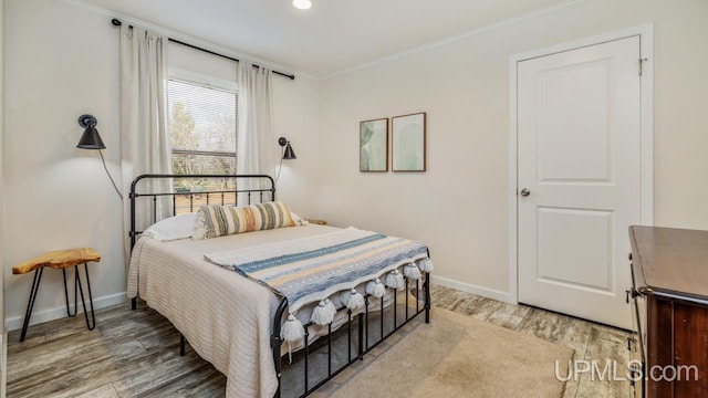 bedroom with hardwood / wood-style flooring and crown molding