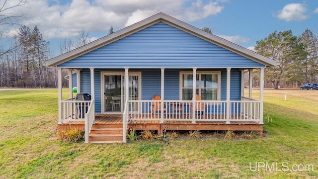 rear view of property featuring a porch and a lawn