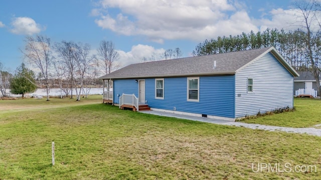 back of property with a lawn, a patio, and a water view