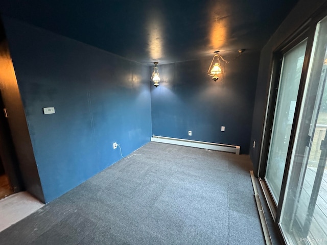 carpeted spare room with a baseboard heating unit