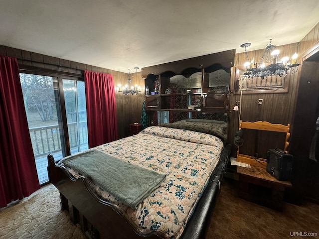 carpeted bedroom featuring wood walls, access to exterior, and a chandelier