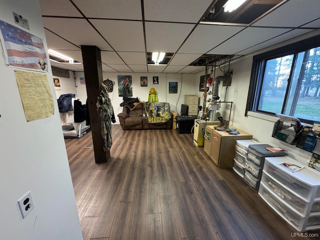 interior space with dark wood-type flooring and a drop ceiling