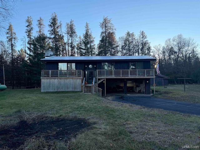 back of property with a wooden deck and a yard