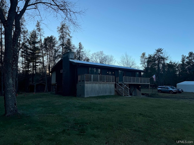 view of front facade featuring a front lawn and a wooden deck