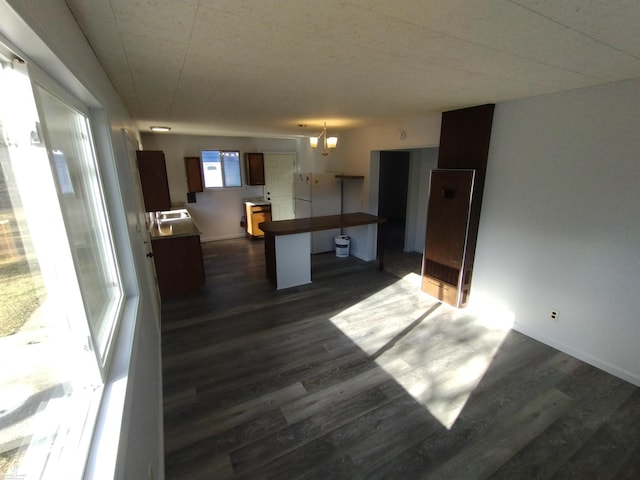 kitchen featuring kitchen peninsula, dark hardwood / wood-style floors, and a breakfast bar area