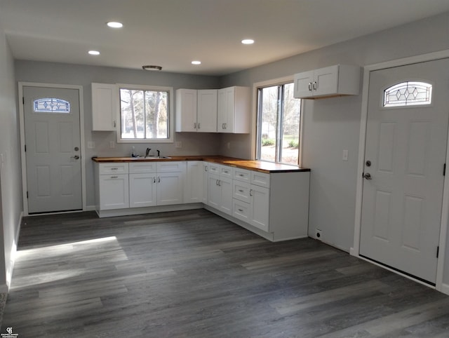 kitchen with white cabinetry, dark hardwood / wood-style flooring, and butcher block countertops