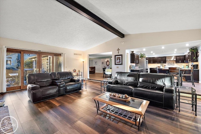 living room with lofted ceiling with beams, dark wood-type flooring, and a textured ceiling