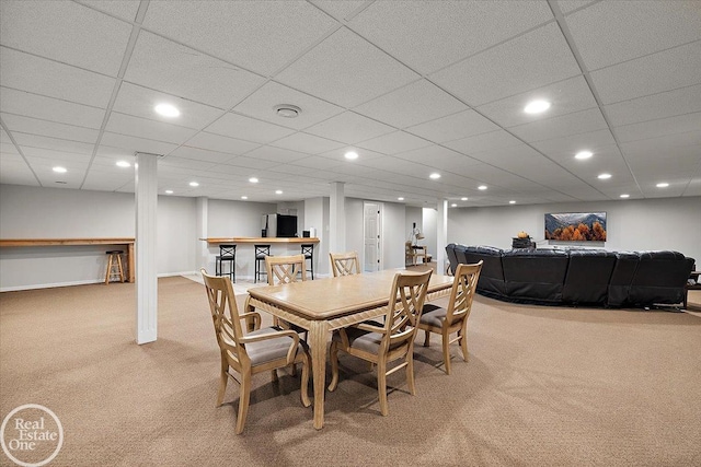 dining area featuring a paneled ceiling and light colored carpet