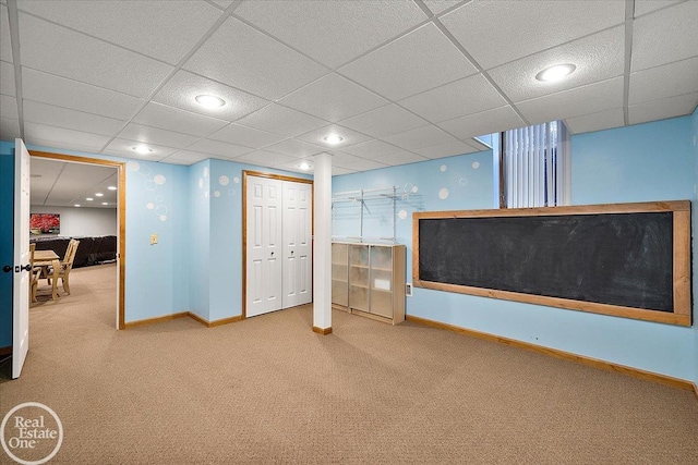 basement featuring carpet flooring and a drop ceiling