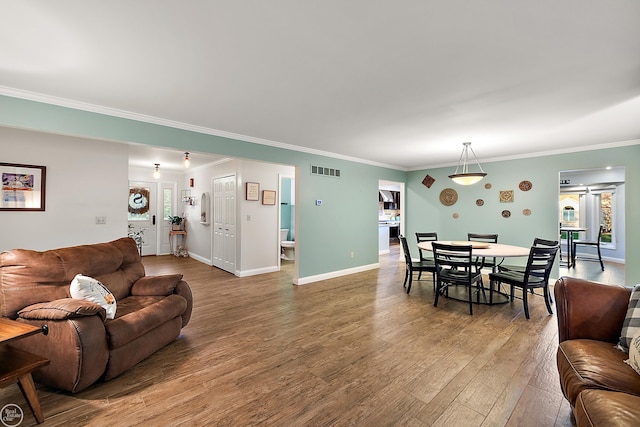 living room with ornamental molding and wood-type flooring