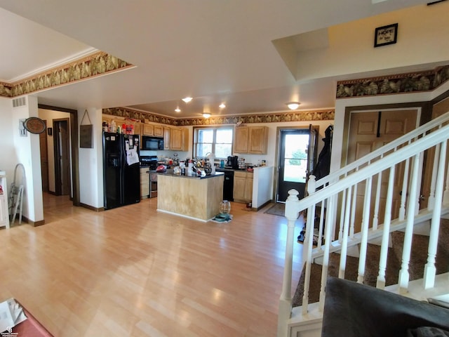 kitchen featuring black appliances, light wood-type flooring, and a center island