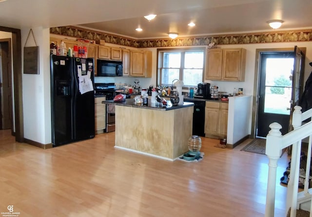 kitchen with light brown cabinets, light hardwood / wood-style floors, black appliances, and a kitchen island