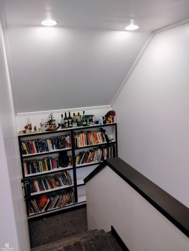 staircase with lofted ceiling, hardwood / wood-style flooring, and crown molding