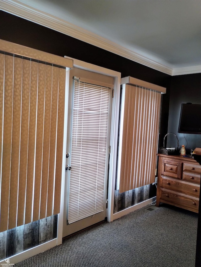 doorway featuring ornamental molding and carpet floors