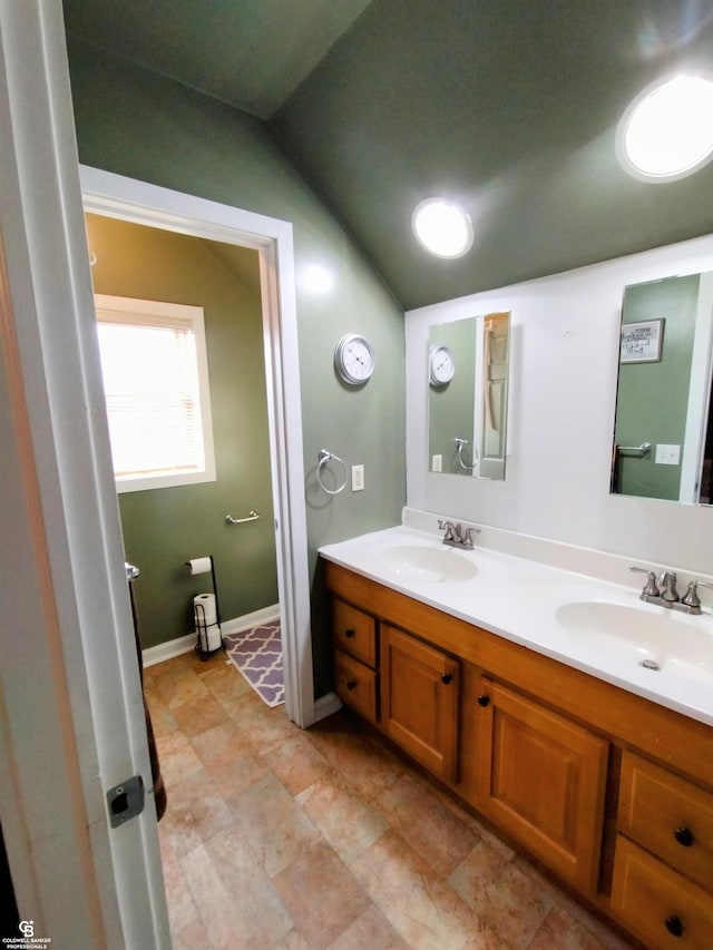 bathroom featuring vanity and lofted ceiling