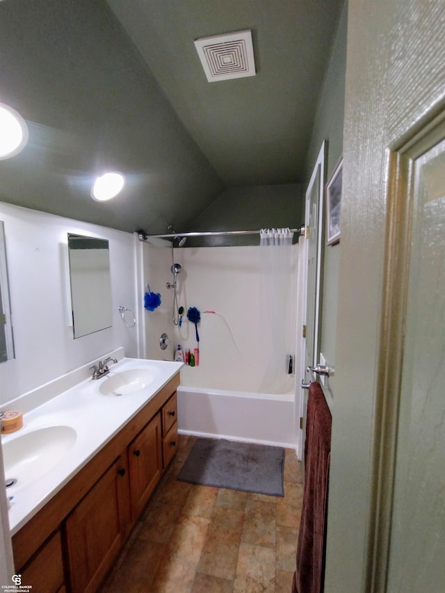 bathroom with vanity, vaulted ceiling, and bathing tub / shower combination