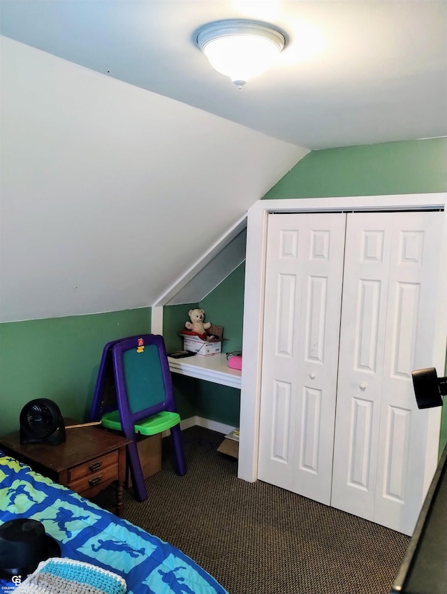 carpeted bedroom with a closet and lofted ceiling