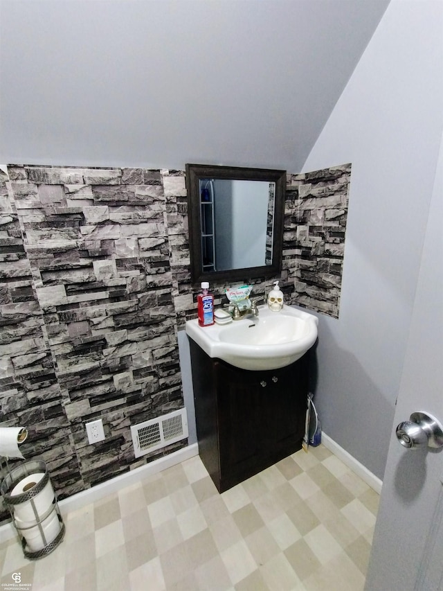 bathroom featuring vanity and lofted ceiling