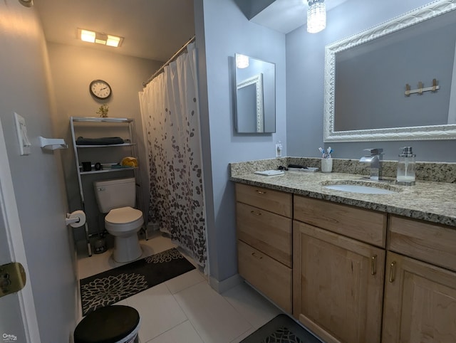 bathroom featuring tile patterned floors, vanity, and toilet