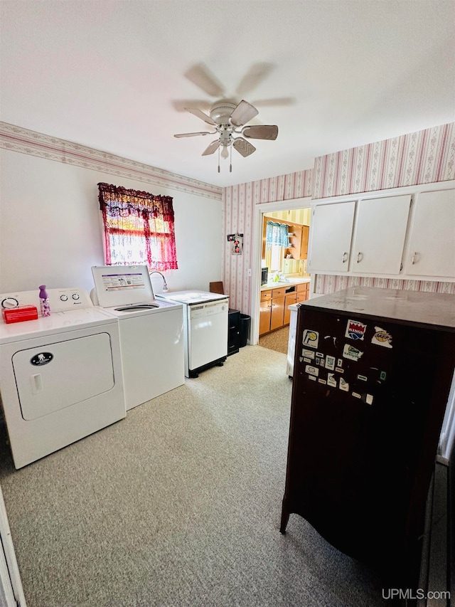 laundry area featuring ceiling fan, light colored carpet, and separate washer and dryer