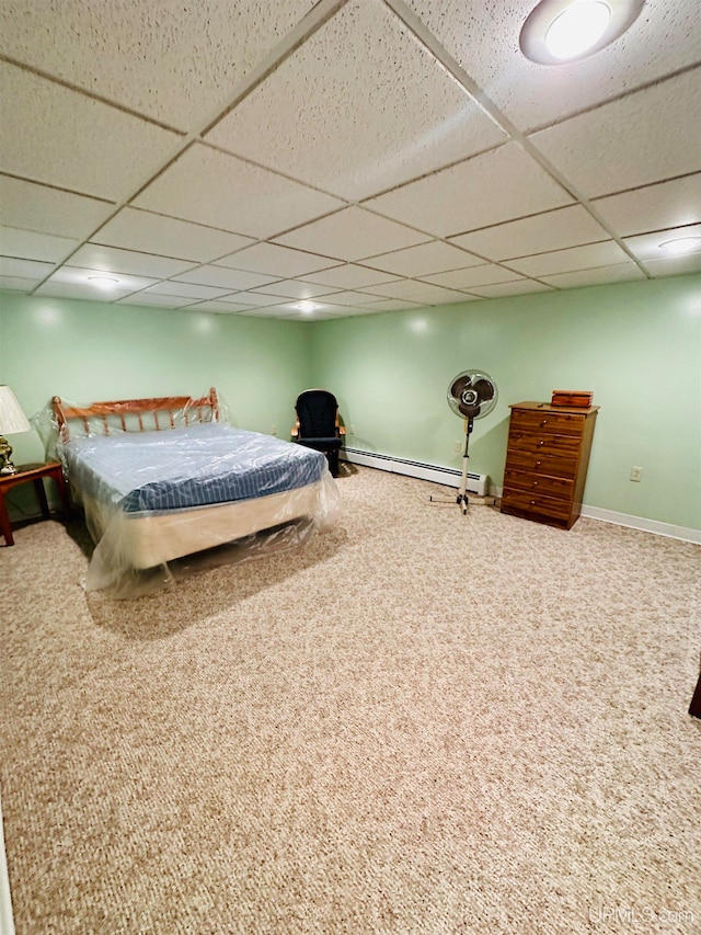 unfurnished bedroom featuring a paneled ceiling, carpet floors, and a baseboard radiator