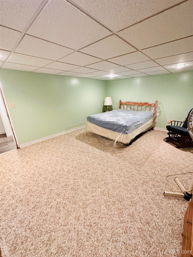 unfurnished bedroom with a drop ceiling and carpet