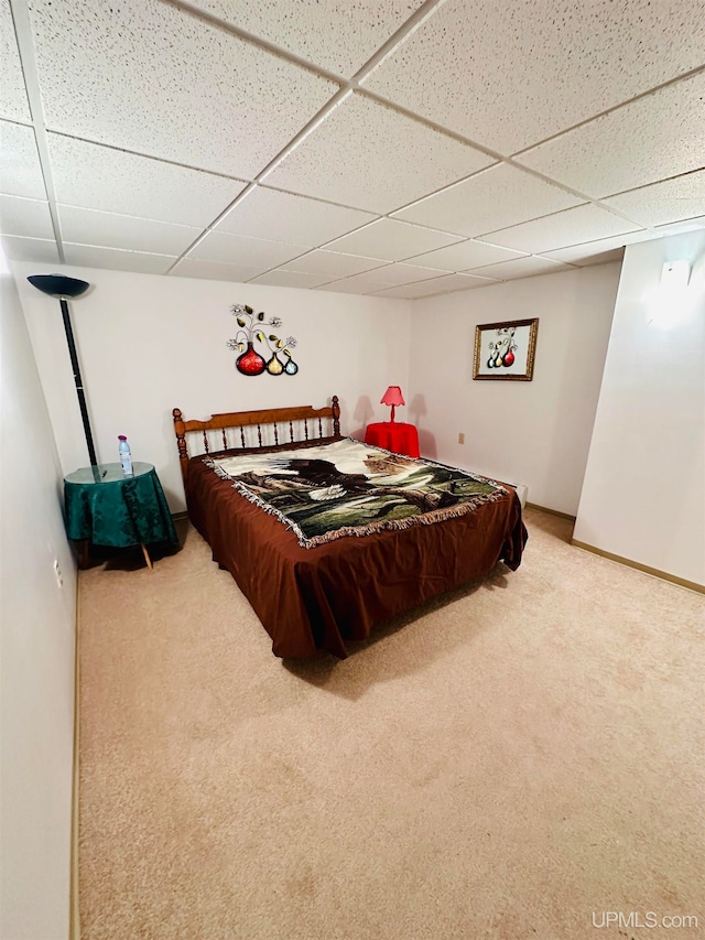 bedroom featuring a paneled ceiling and carpet floors