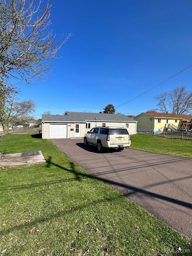 ranch-style house with a garage and a front lawn