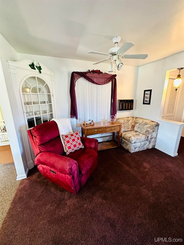 carpeted living room featuring baseboard heating and ceiling fan