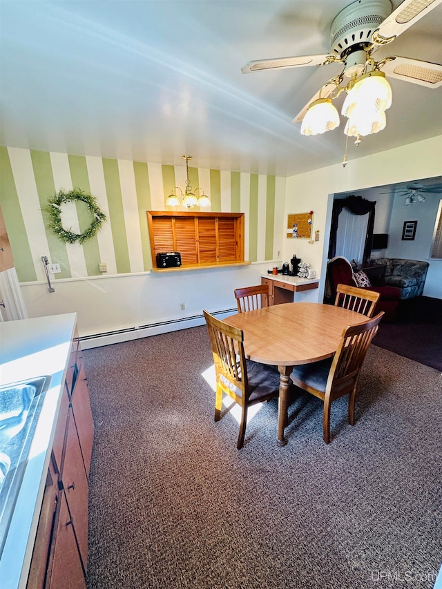 dining area featuring baseboard heating, ceiling fan with notable chandelier, and dark carpet