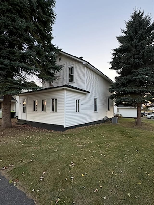 view of home's exterior featuring central AC and a lawn