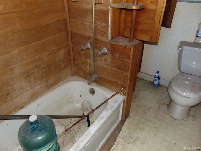 bathroom featuring tile walls, toilet, and shower / bathing tub combination