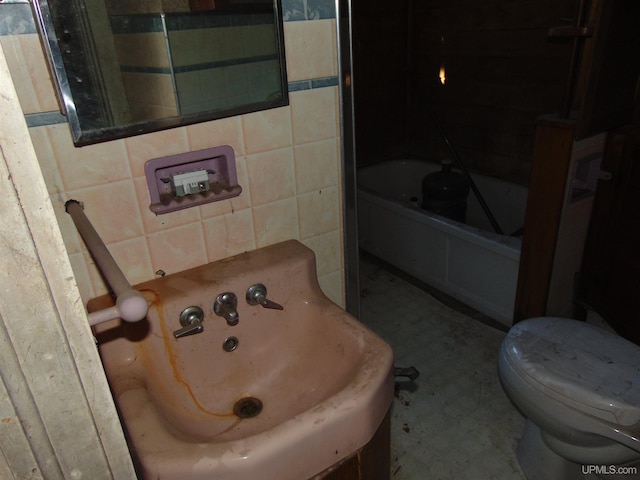 bathroom with tile walls, toilet, and tub / shower combination