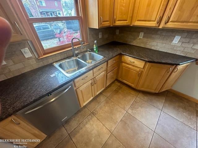 kitchen featuring backsplash, dishwasher, sink, and light tile patterned floors