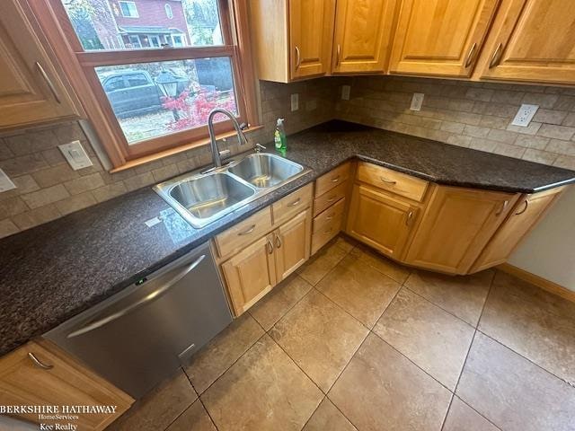 kitchen with decorative backsplash, dark stone counters, sink, light tile patterned floors, and dishwasher