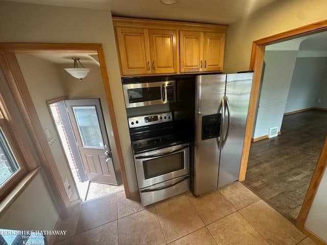 kitchen with light tile patterned floors and appliances with stainless steel finishes