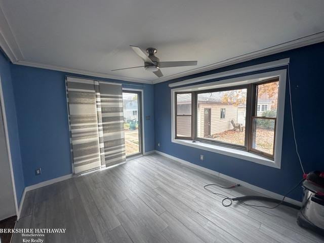 spare room featuring crown molding, plenty of natural light, ceiling fan, and hardwood / wood-style flooring