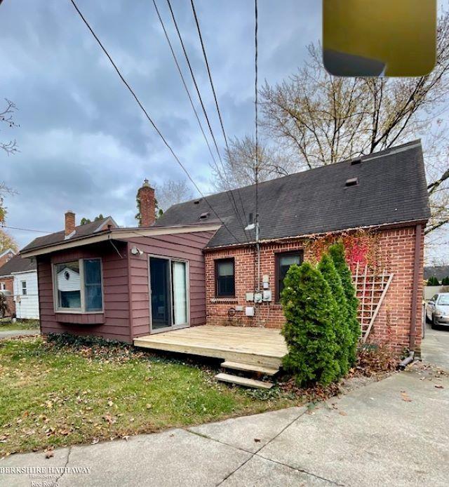 rear view of house with a lawn and a wooden deck