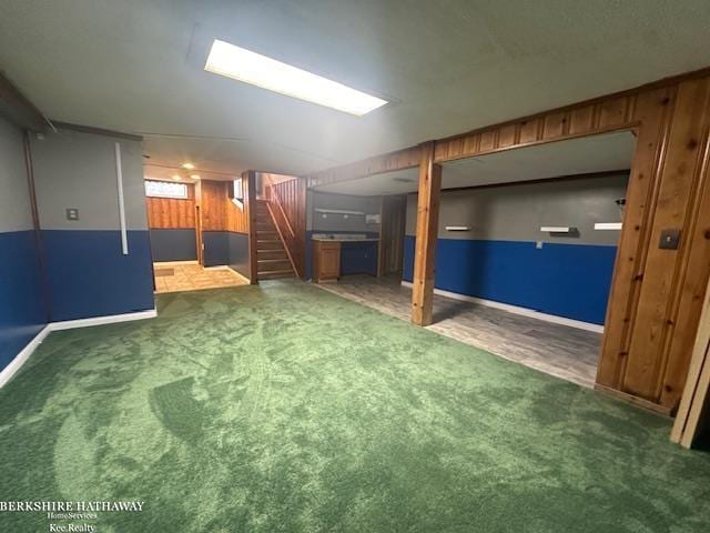 basement with wooden walls and dark carpet