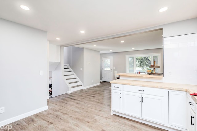 kitchen with white cabinets and light hardwood / wood-style flooring