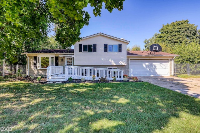 tri-level home with a deck, a front yard, and a garage