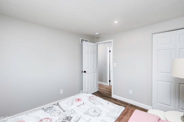 bedroom featuring dark hardwood / wood-style floors and a closet