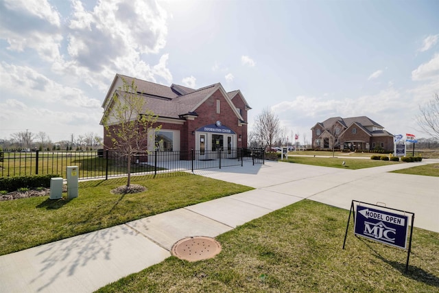 view of front of home with brick siding, a front yard, and fence