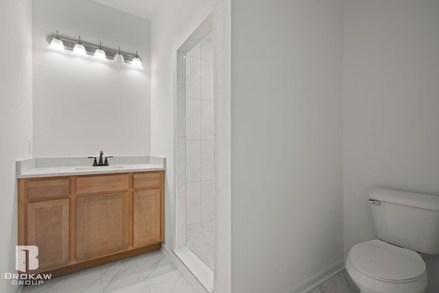 bathroom with vanity, toilet, and a tile shower