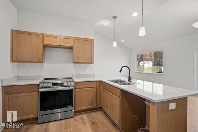 kitchen with sink, kitchen peninsula, pendant lighting, light wood-type flooring, and stainless steel range