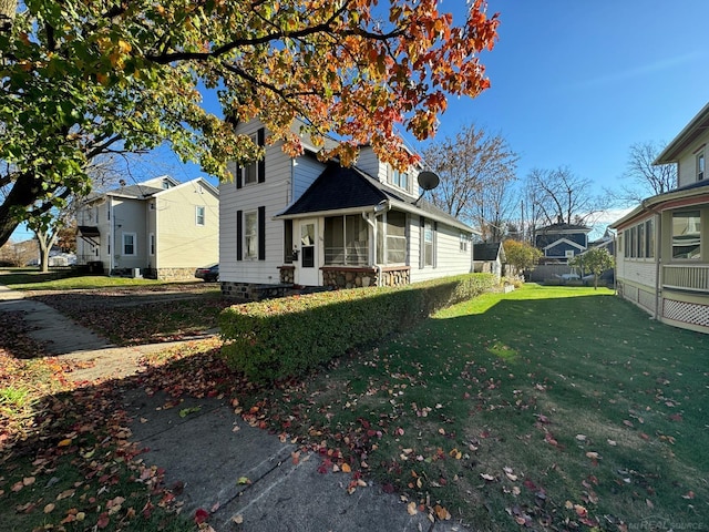 view of front facade featuring a sunroom and a front lawn