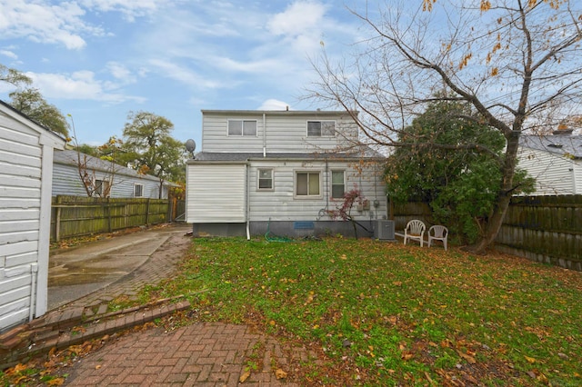 back of house featuring a yard and central AC unit