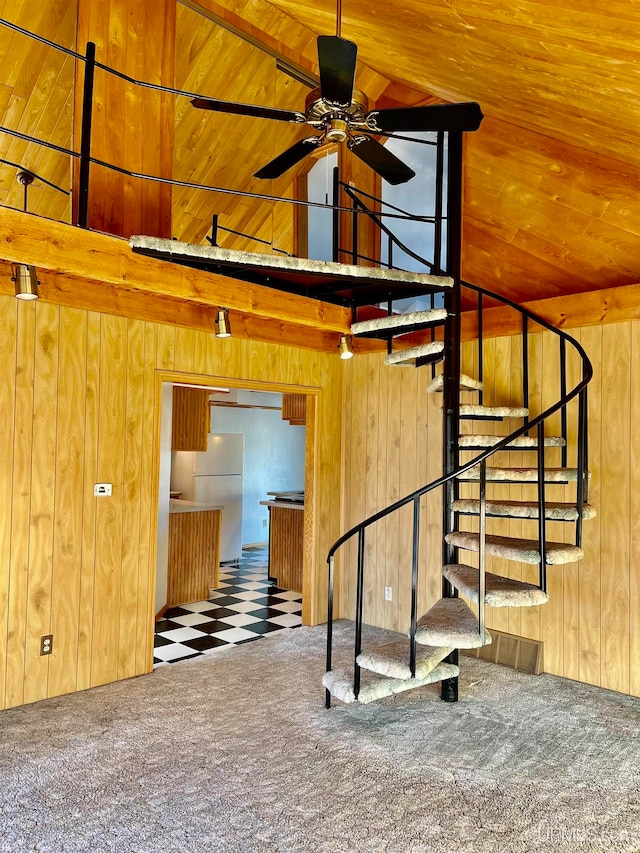 stairs with wooden ceiling, ceiling fan, wooden walls, and carpet floors