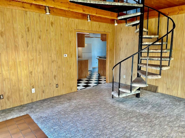 stairs featuring wooden walls, carpet floors, and beam ceiling