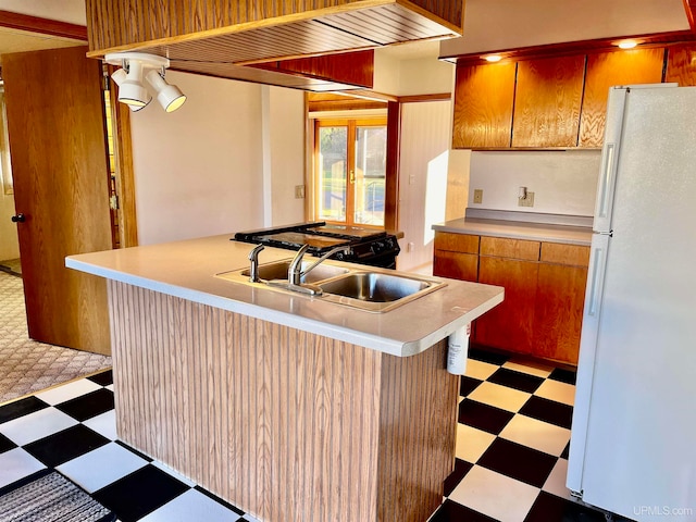 kitchen featuring french doors, white refrigerator, kitchen peninsula, sink, and a kitchen breakfast bar